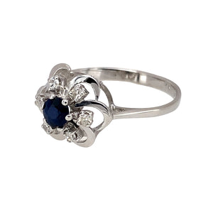 Preowned 14ct White Gold Diamond & Sapphire Set Flower Ring in size O to P with the weight 2.30 grams. The sapphire stone is 4mm diameter and the front of the ring is 12mm high