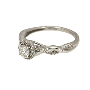 Preowned 9ct White Gold & Diamond Set Solitaire Halo Ring in size N with the weight 2.30 grams. There is approximately 0.25ct of diamond content set in total and the twisted shoulders are diamond set