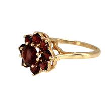 Load image into Gallery viewer, Add a touch of vintage elegance to your jewellery collection with this pre-owned 9ct yellow gold &amp; garnet set flower cluster ring, featuring:

Design: A stunning flower cluster ring, with a beautifully arranged garnet centerpiece creating a timeless floral-inspired look.
Material: 9-carat yellow gold, offering a warm and classic appeal.
Gemstone: Features a 6mm diameter central garnet, known for its deep red hue and rich beauty.

