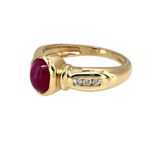 Load image into Gallery viewer, Add a touch of timeless elegance to your jewellery collection with this pre-owned 9ct yellow gold cabochon set ruby &amp; cubic zirconia ring, featuring:

Design: A sophisticated cabochon-set ruby ring, accented with sparkling cubic zirconia for added brilliance.
Material: 9-carat yellow gold, offering a warm and luxurious appeal.
Gemstone: Features a 7mm by 5mm cabochon-cut ruby, known for its rich red hue and smooth, polished finish.
Accent Stones: Enhanced with cubic zirconia, adding a refined sparkle to the
