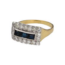 Load image into Gallery viewer, Preowned 18ct Yellow and White Gold Diamond &amp; Sapphire Set Vintage Style Ring in size L with the weight 4.20 grams. The front of the ring is 9mm high. The ring is made up of 54pt of diamond content in total and three emerald cut sapphire stones
